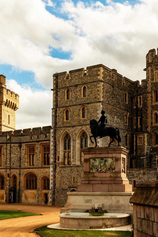 a statue of a man riding on a horse with a castle in the background