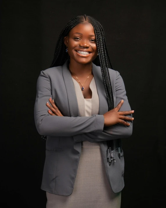 a female wearing a gray jacket standing with her arms folded