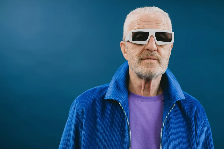 an old man wearing white shades and wearing a purple shirt