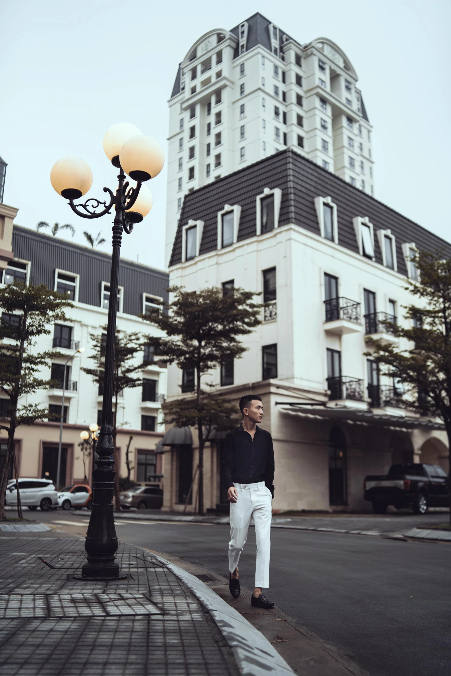 the man is standing in front of a building on a street corner