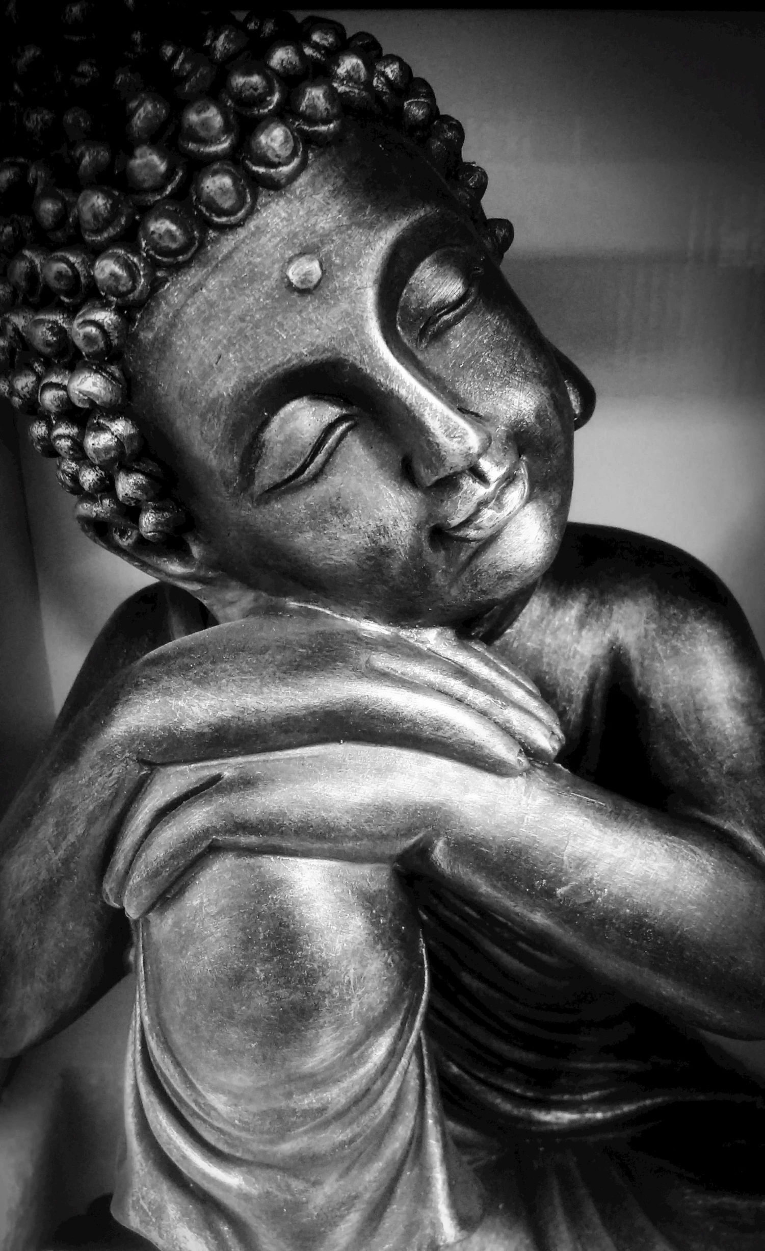 a close up view of the head and hands of a buddha statue