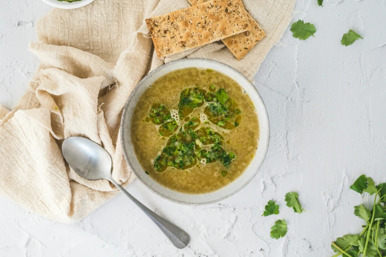 a bowl of soup with broccoli, cheese, and ers