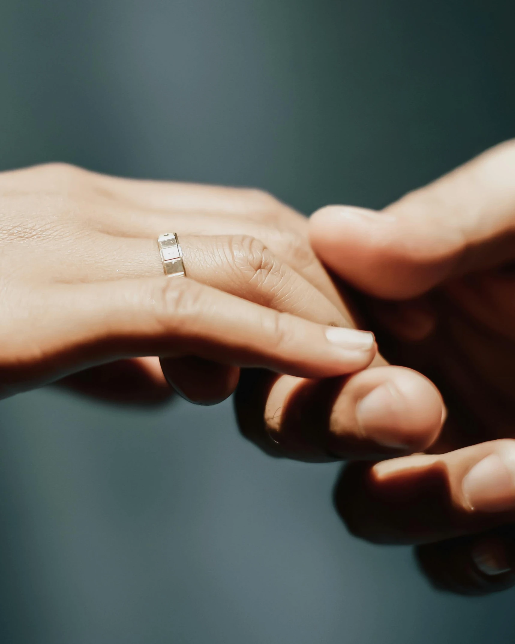 two people holding hands with a diamond ring on top