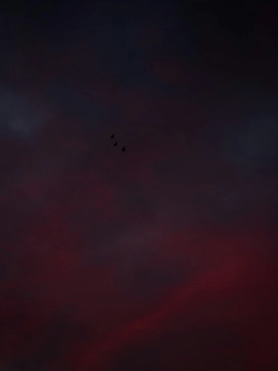 two planes flying in formation under dark sky