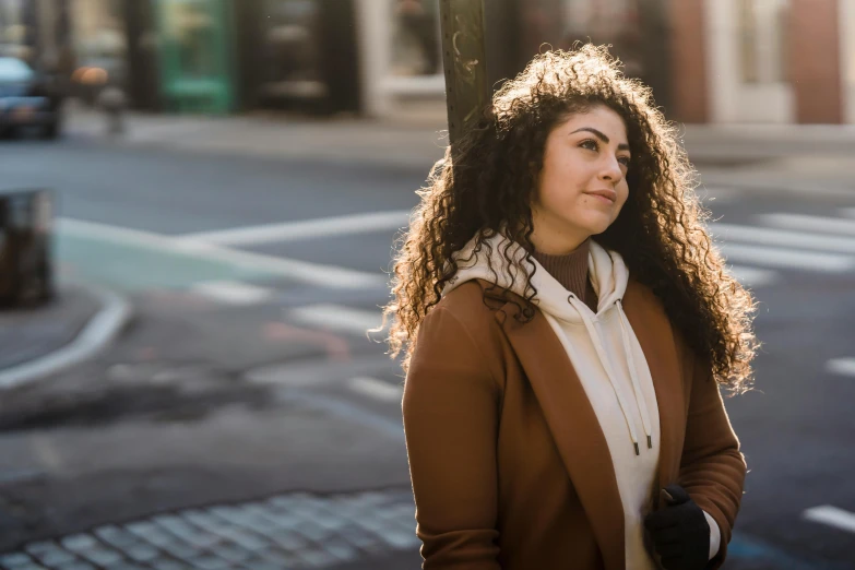 a woman is standing on the corner of a street