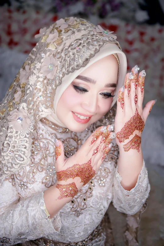 an asian woman with the hands covered in gold and diamonds