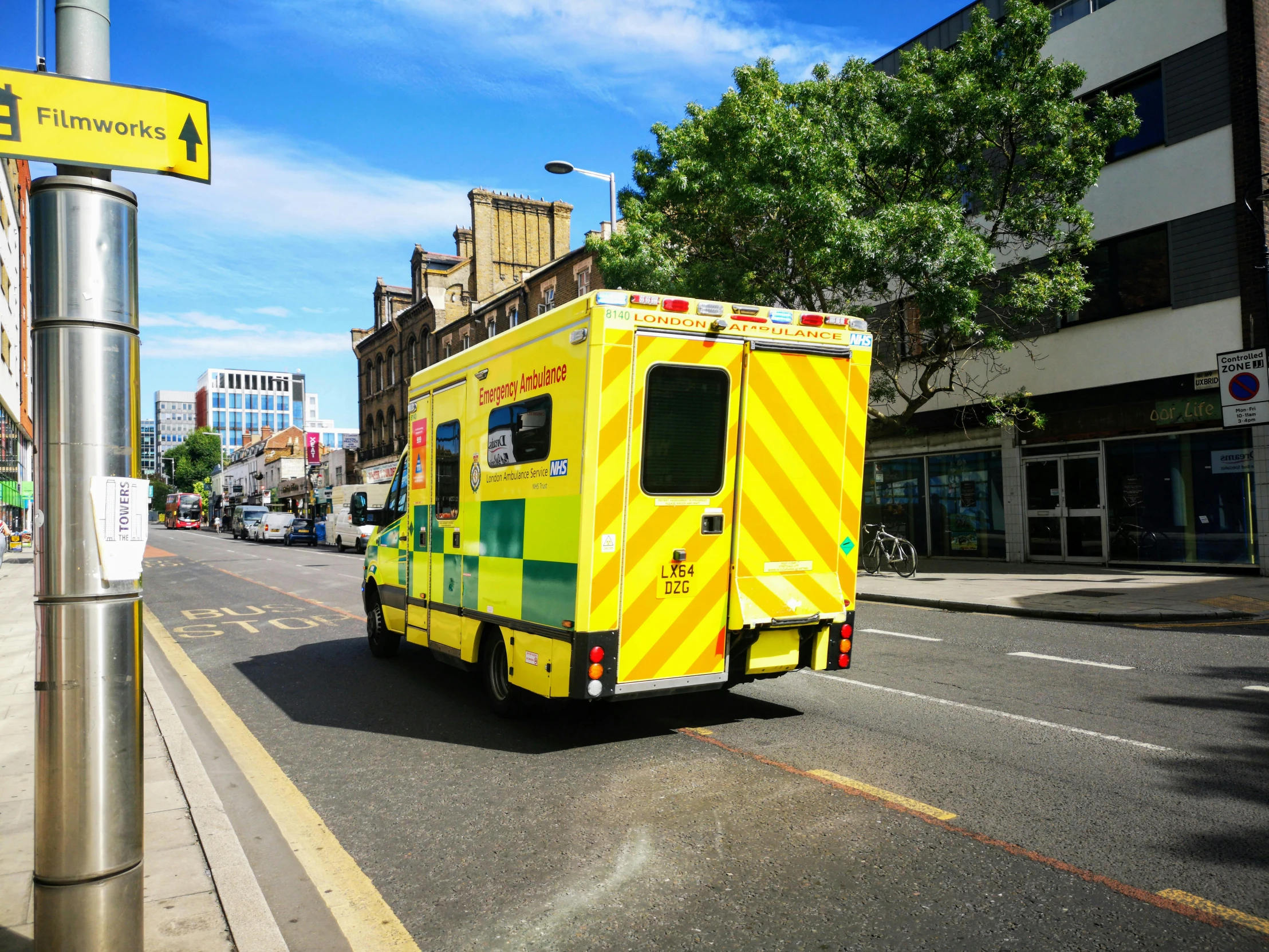 an ambulance is on the road next to a street sign