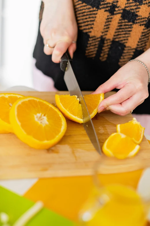 a person  up oranges on a wooden  board