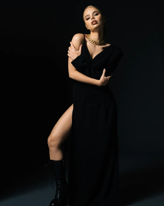 the woman is posing in her long black dress