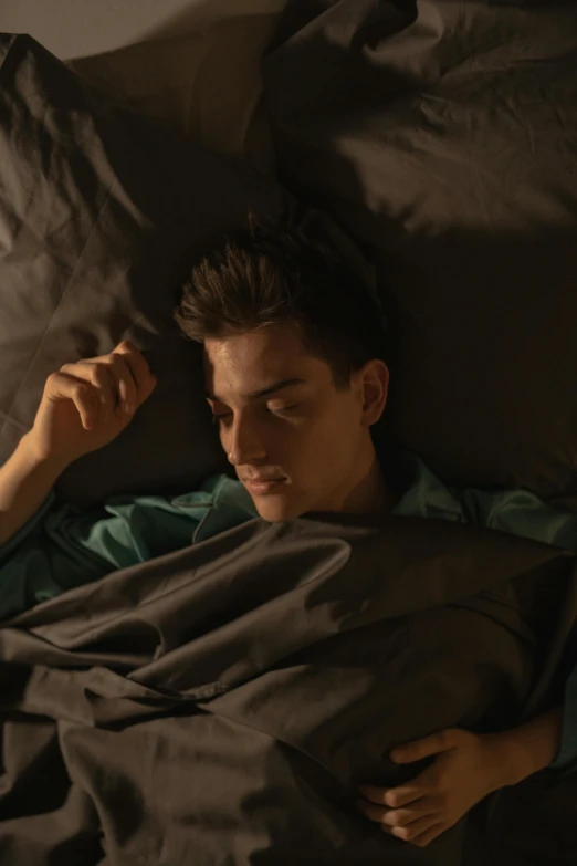 a man is laying down in bed with his head near an pillow