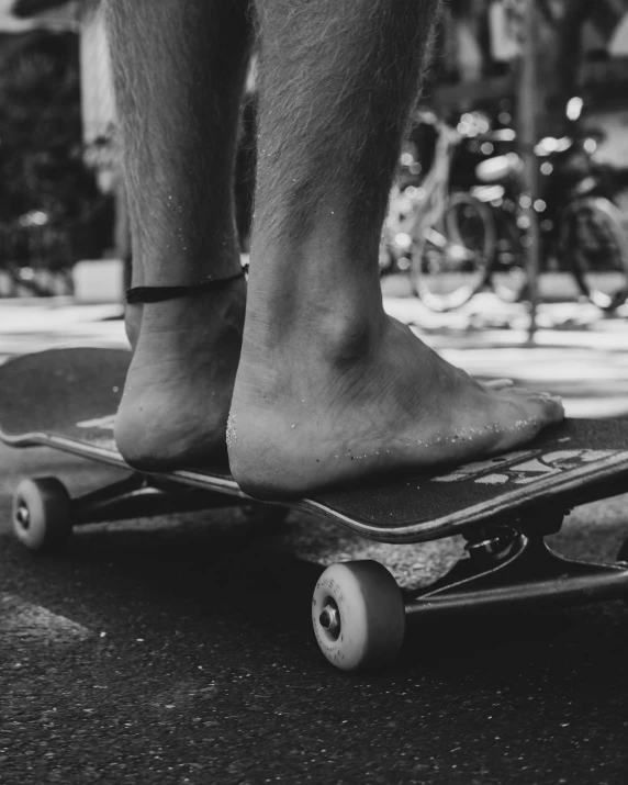 a man standing on top of a skateboard while wearing sandals