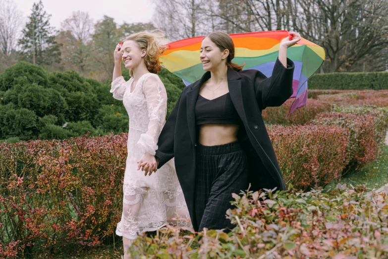 two women are walking with a kite in their hands