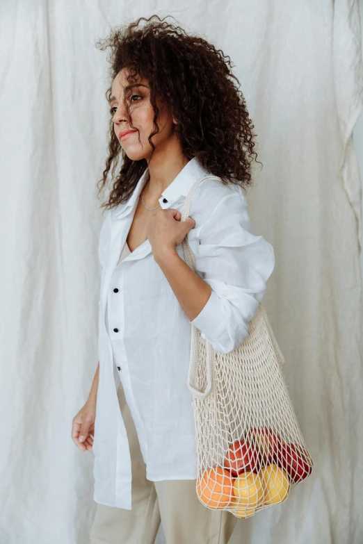 a woman smiles as she holds onto a bag of produce