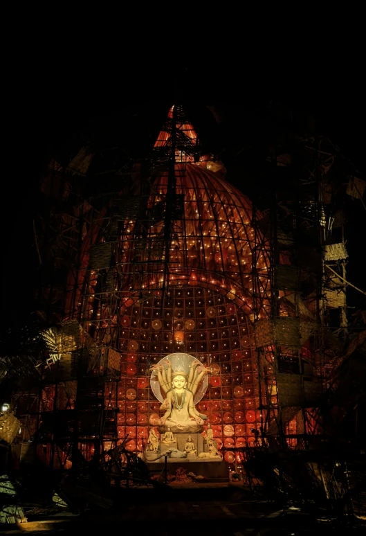 a light sculpture with a buddha statue sitting in front of it