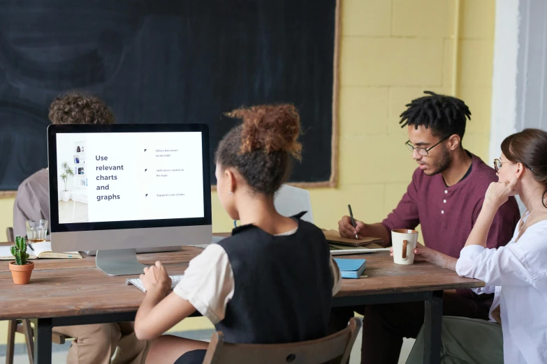 people sitting at a table working on a computer