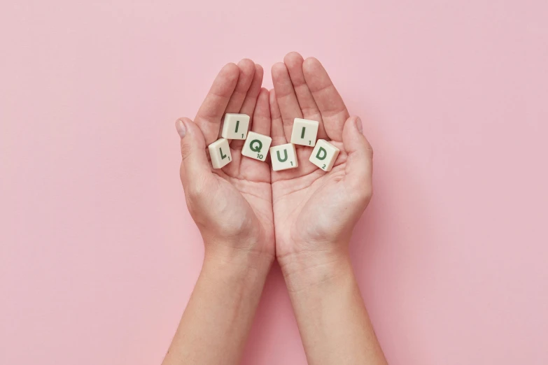 a person holding out their hands with scrabbles spelling hello