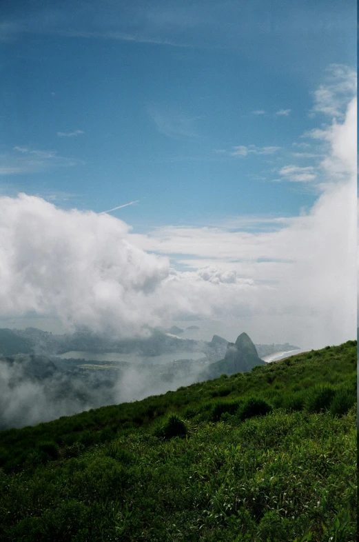 a hill is covered with clouds and grass