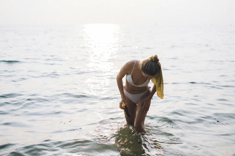 a woman standing in water on her cell phone