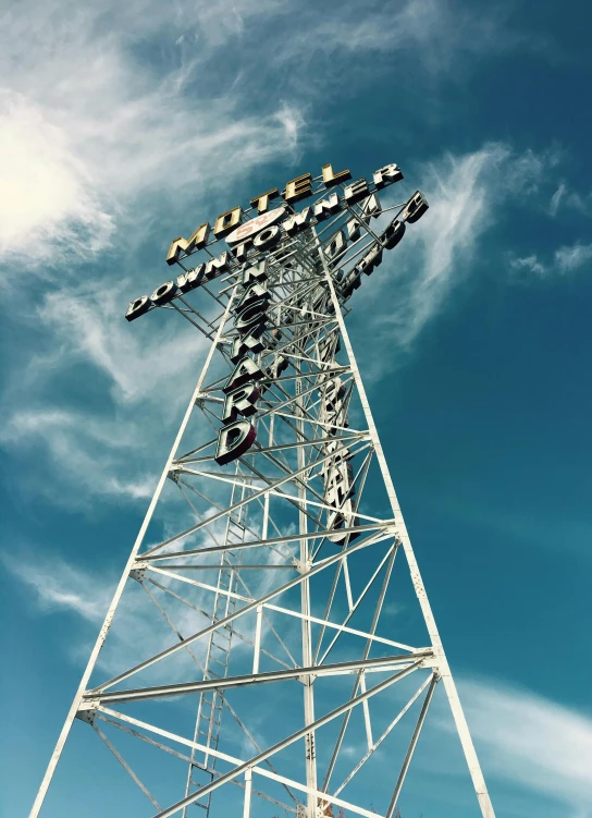 a very tall electrical tower towering in the blue sky