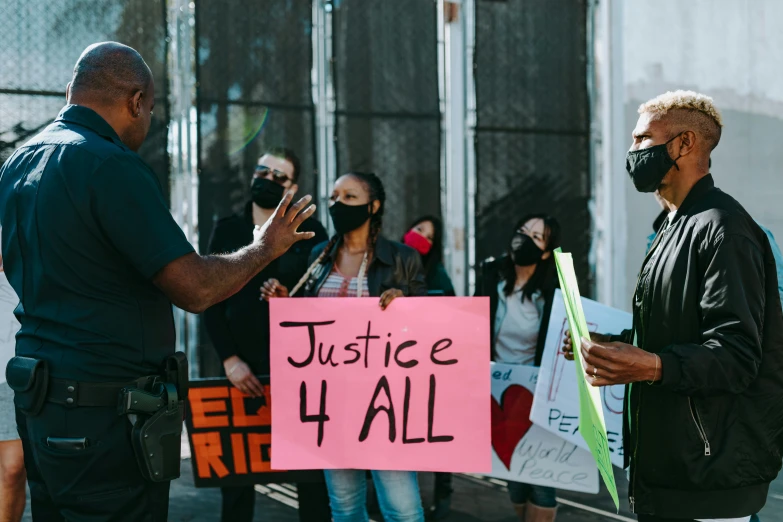 protestors holding signs and wearing masks in a street