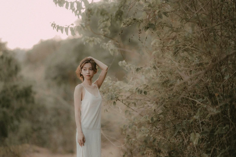 a woman is standing with her arms over her head in a dress