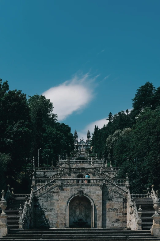 a castle structure with steps and trees in the background