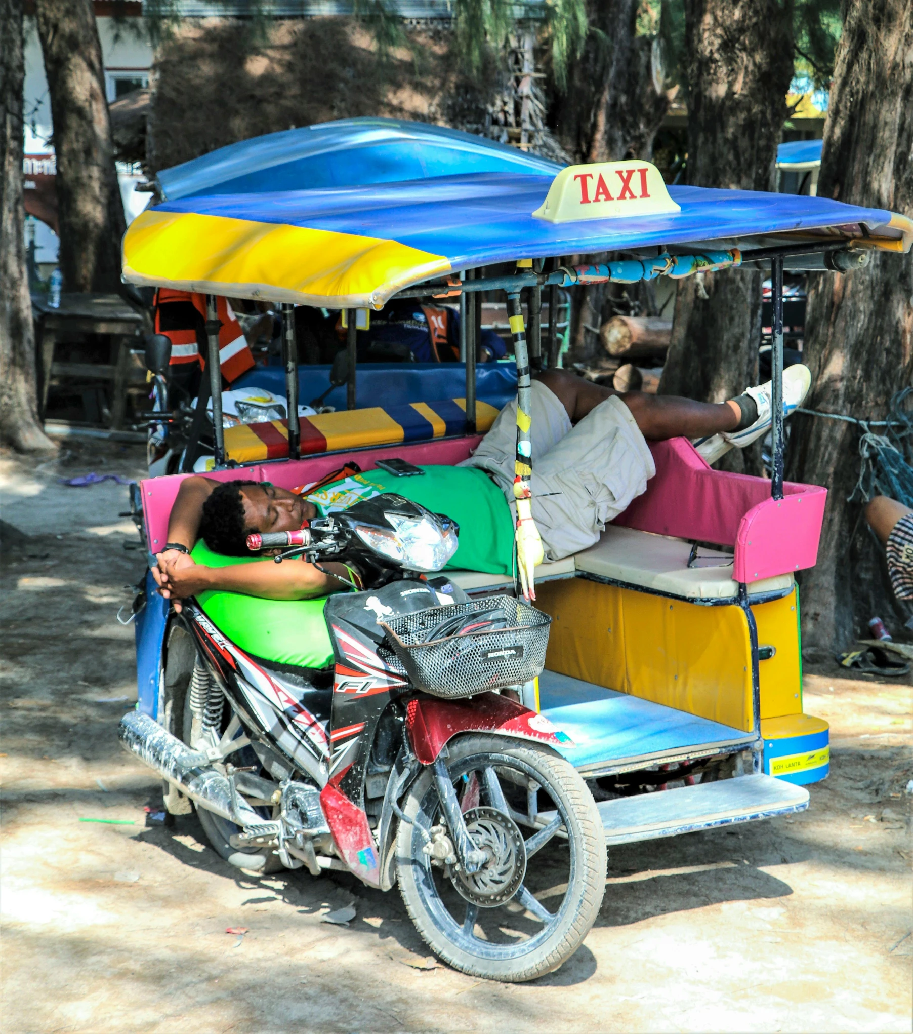 a motorcycle parked next to a blue covered taxi