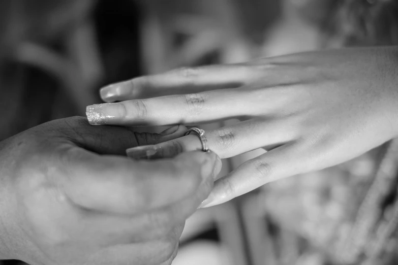 two people putting ring on each other's finger