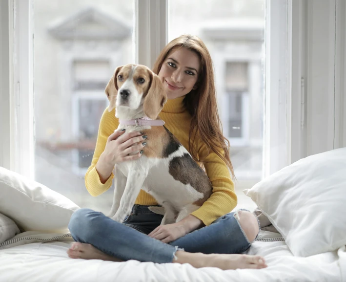 a woman holding a dog sitting on her lap