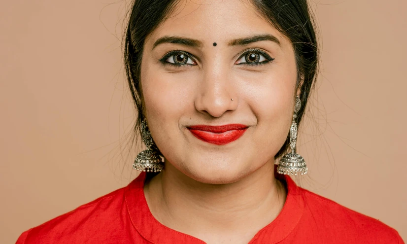 a woman is smiling for the camera and has a bright red dress on