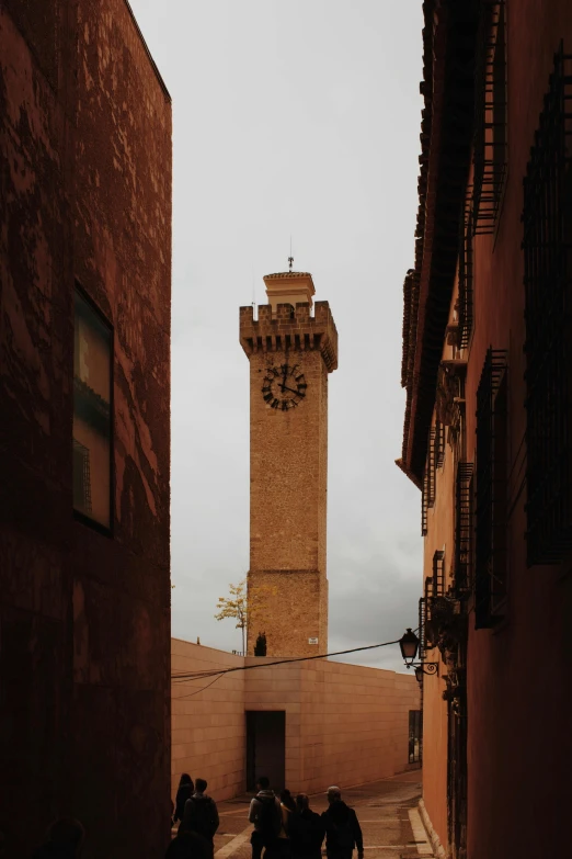 a tall tower with a clock is surrounded by people