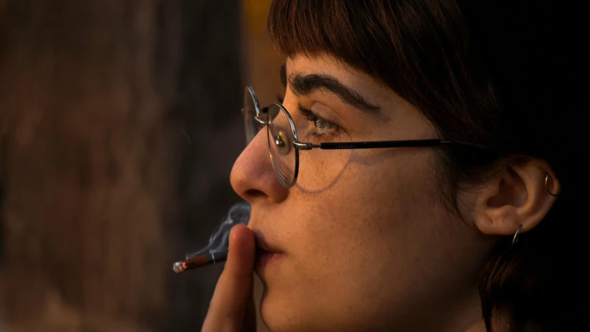 a woman with glasses smoking a cigarette