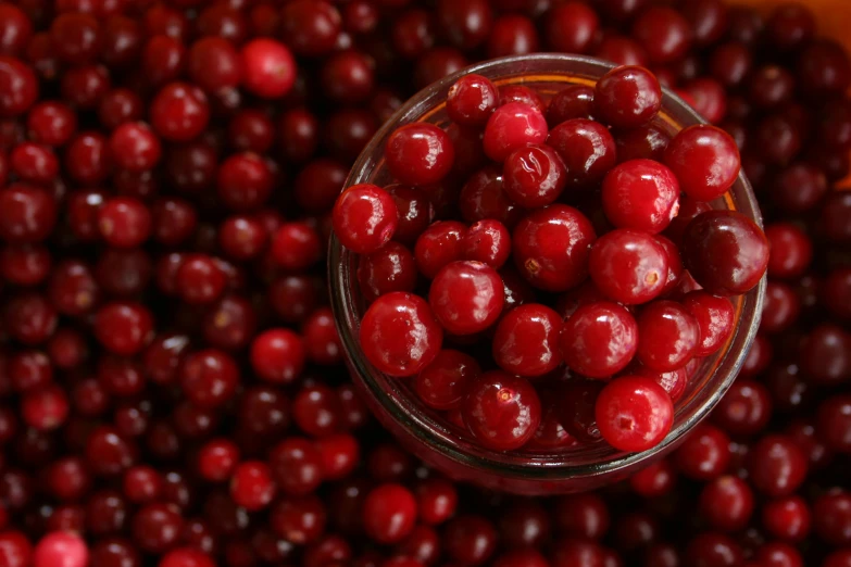 a bowl of cherries in a red, orange and yellow bowl