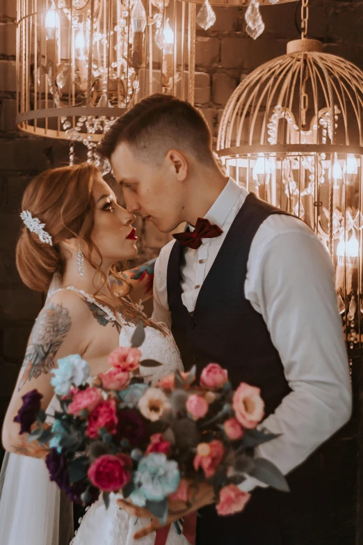 a young bride and groom standing together in front of the chandelier