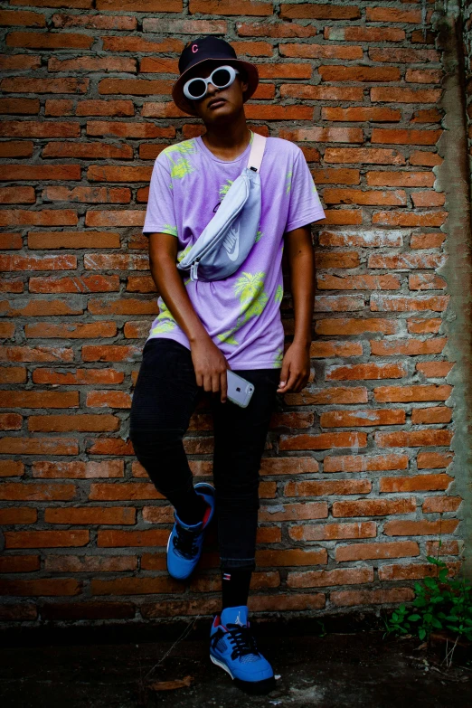 a boy in purple is leaning against the wall