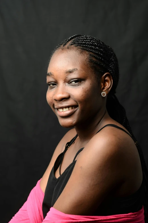 a woman in a pink dress with a black backdrop