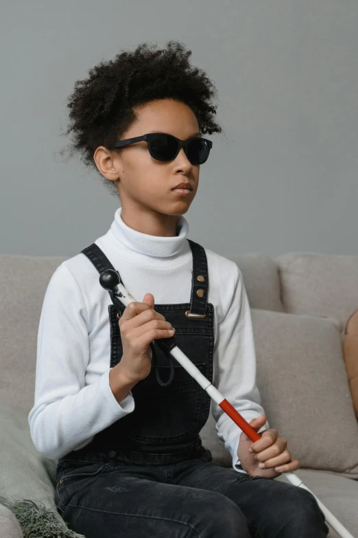 a boy with sun glasses and eye glasses sitting on a couch