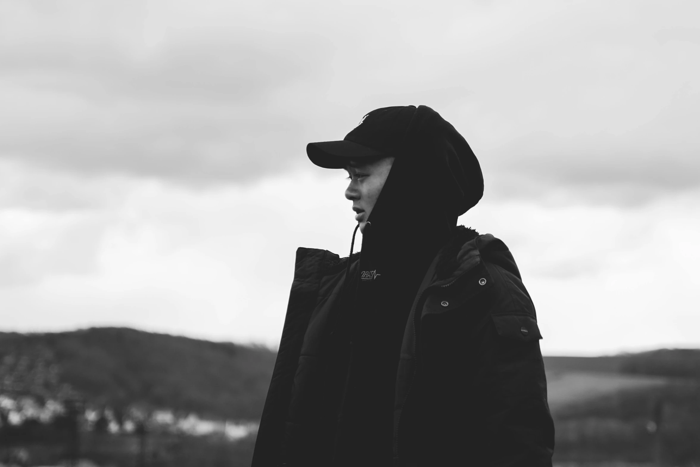 a person in a hooded jacket standing in the snow