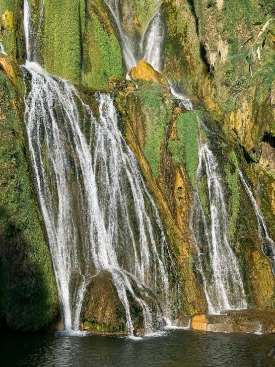 a waterfall is located on the side of a hill