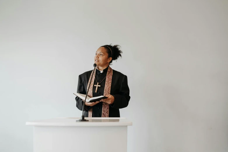 a priest holds his book while standing on top of a podium