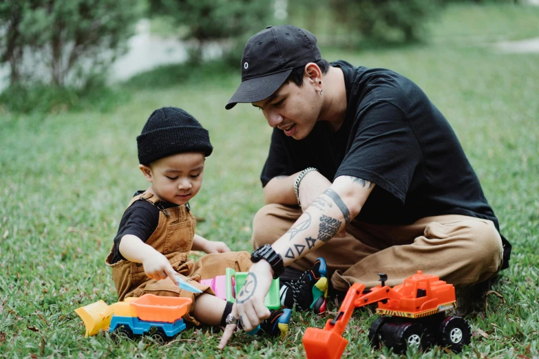 a man and a small child playing with toys in the grass