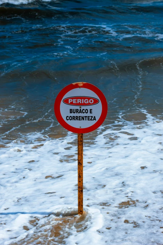 a road sign on a beach covered in snow