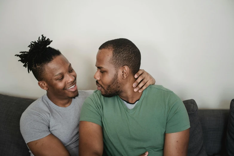 a couple of men sitting on top of a couch