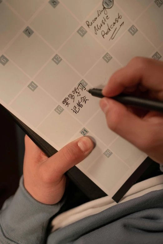 a man holding a pen with writing on the paper
