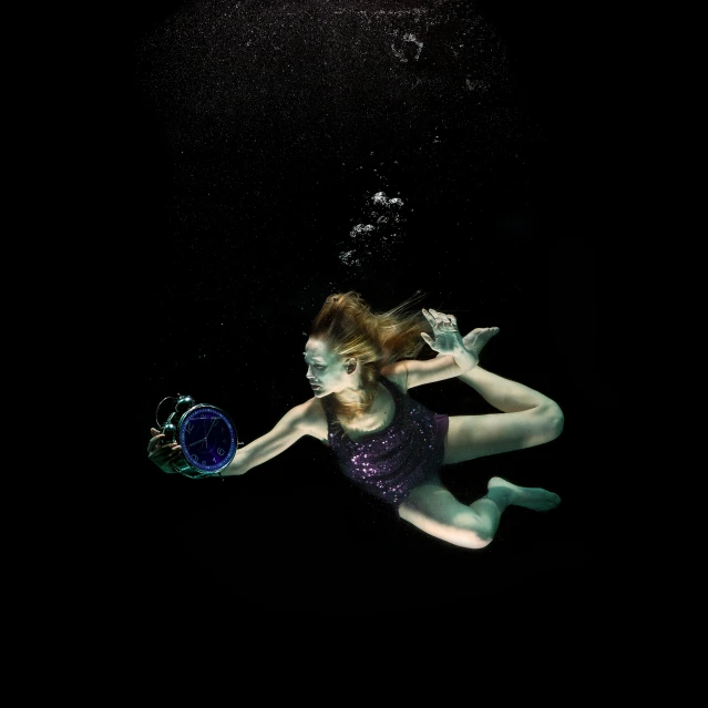 a woman wearing a purple leoter is underwater