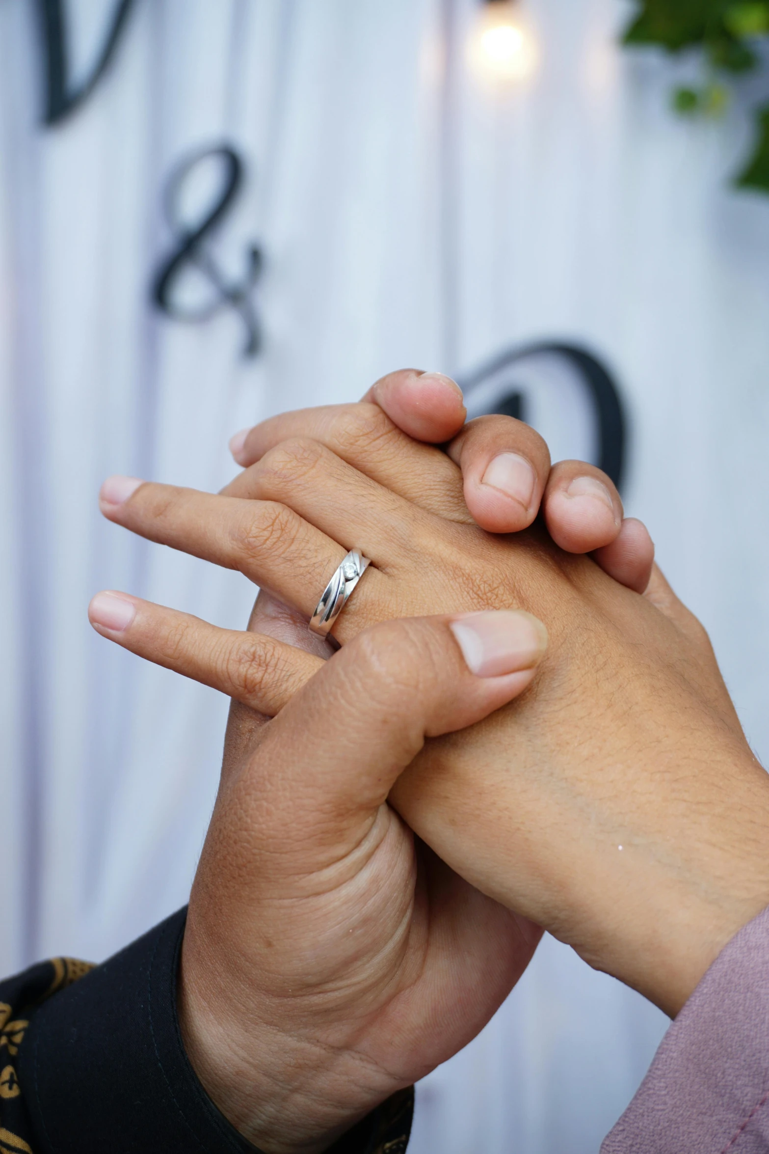 a woman is holding the hand of her boyfriend who is wearing a wedding ring