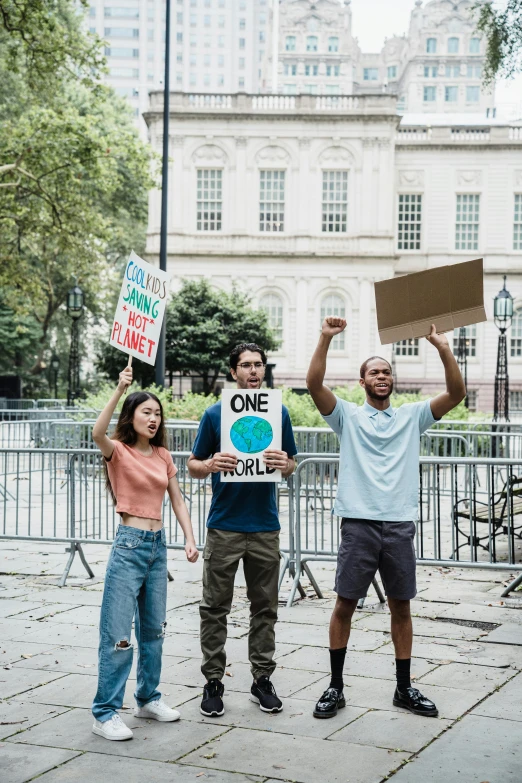 three people standing next to each other holding up signs