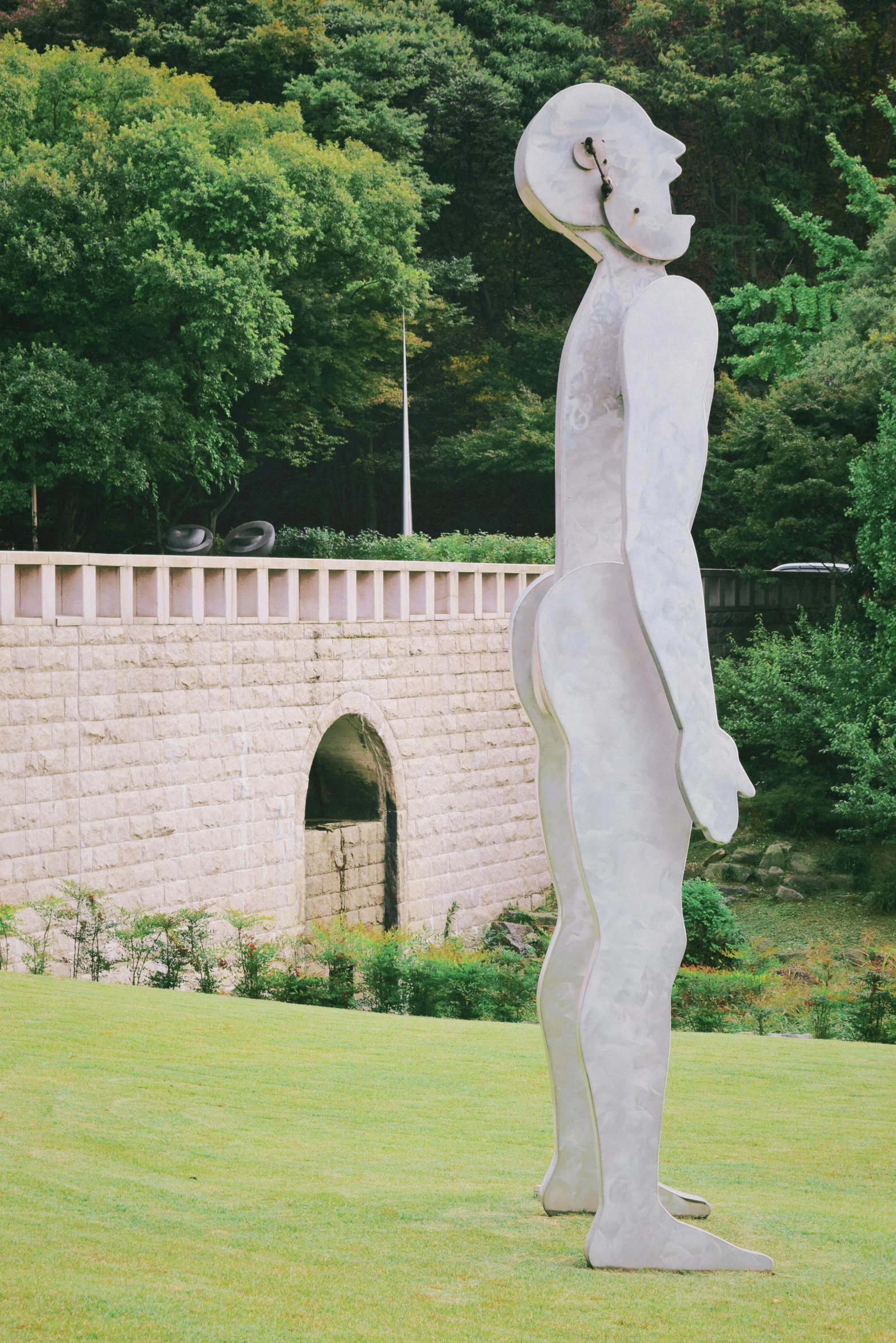 a concrete statue of a woman is in a field