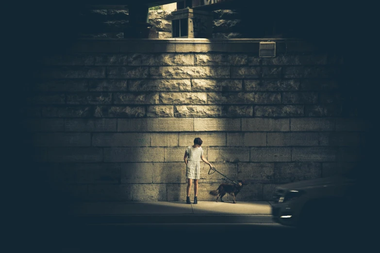 a woman standing under a light in a dark tunnel