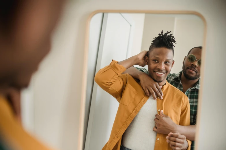 a man looks into a mirror with a yellow jacket